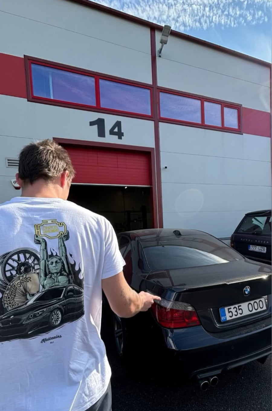 Person opening a car door in front of a building with the number 14