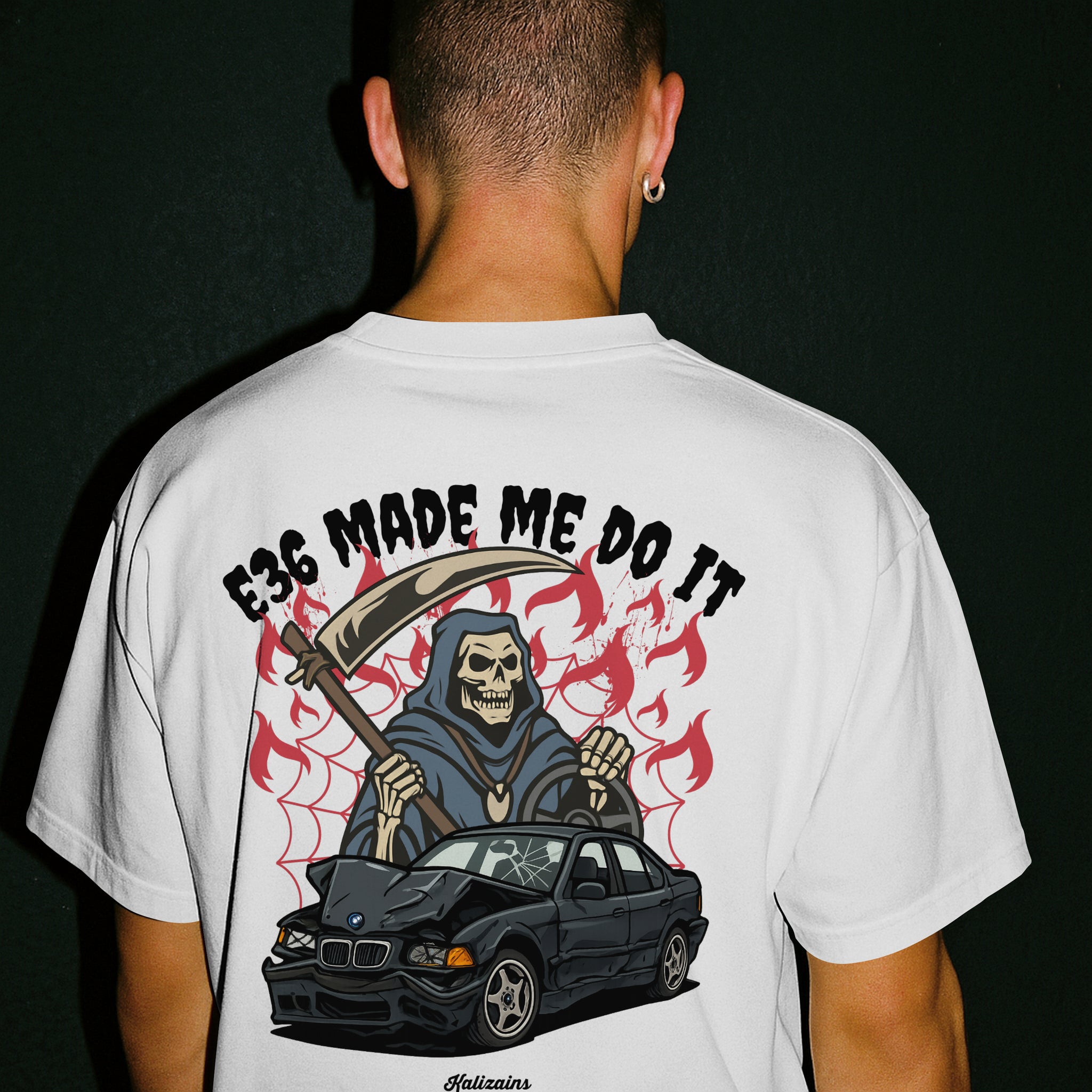 Person wearing a white t-shirt with a graphic design on the back featuring a grim reaper and a car, with text 'E36 MADE ME DO IT'.
