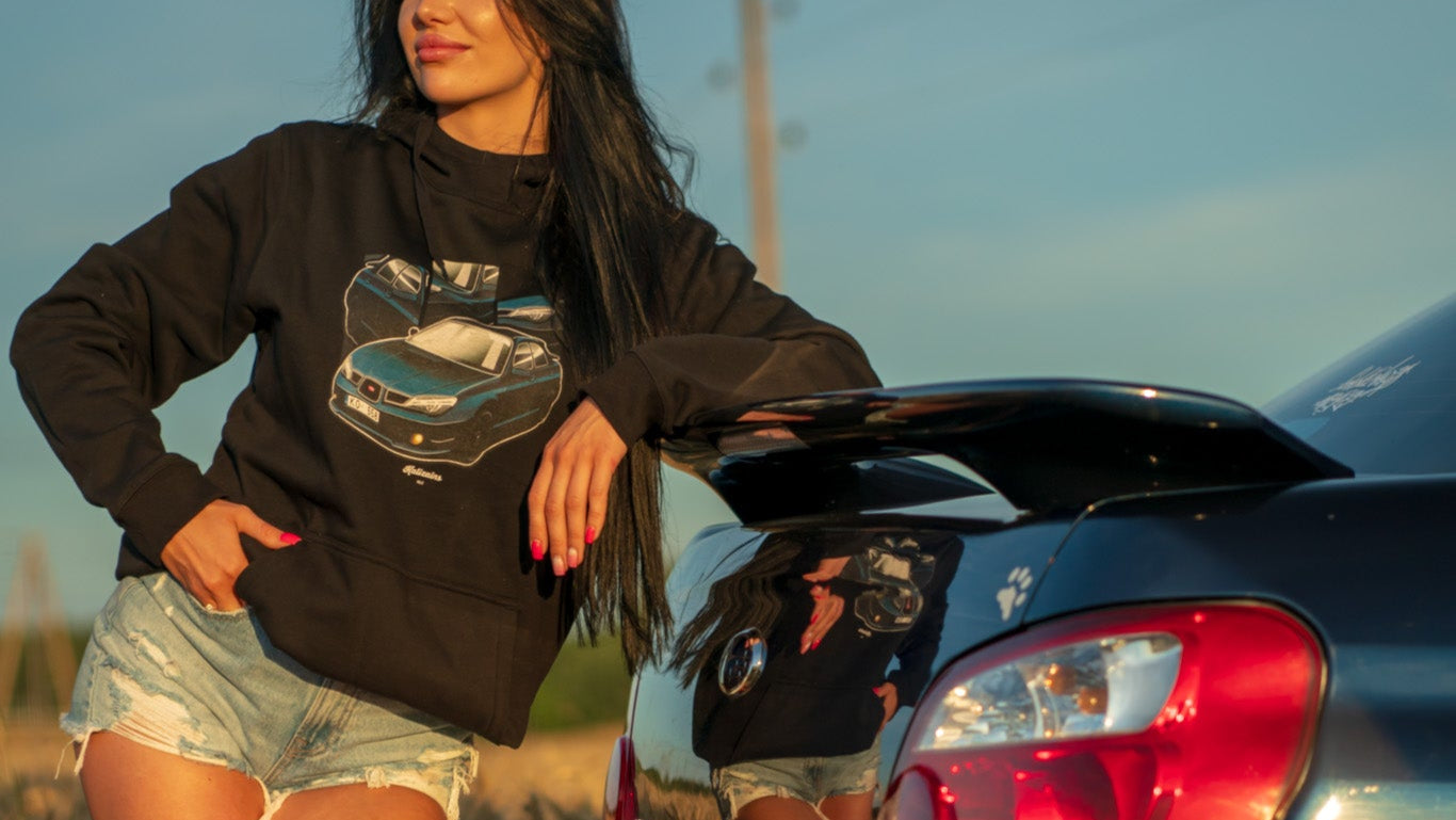 Woman standing next to a car in a field with sunset lighting